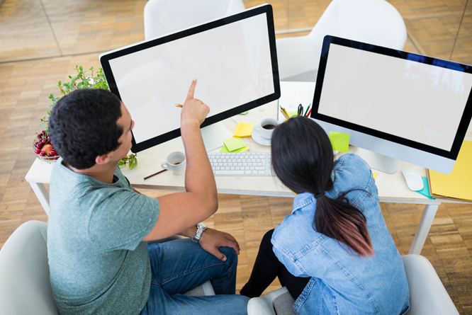 Pessoas em mesa de escritório apontando para computador