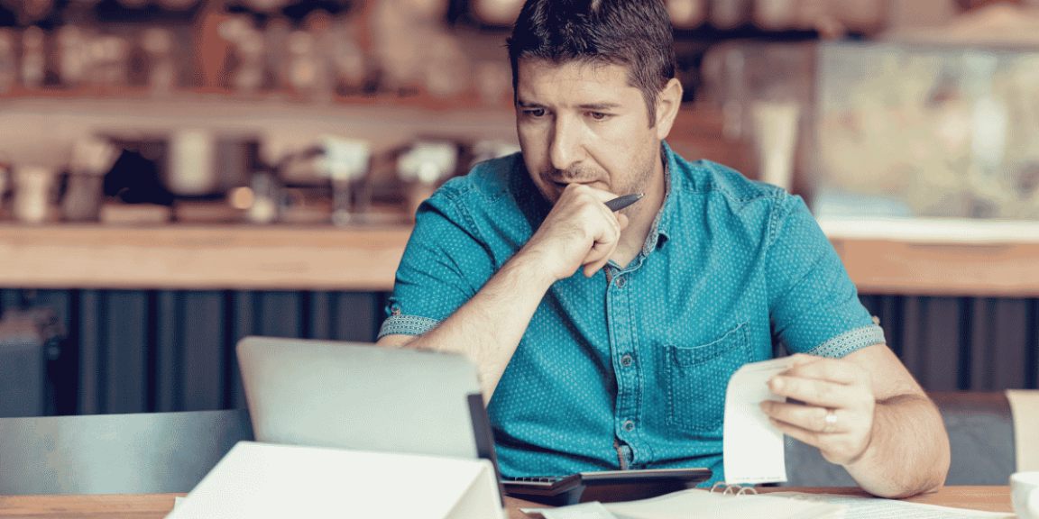 Homem analisando dados na nota fiscal e no tablet