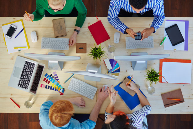 Colaboradores em mesa de reunião discutindo estratégias para startup