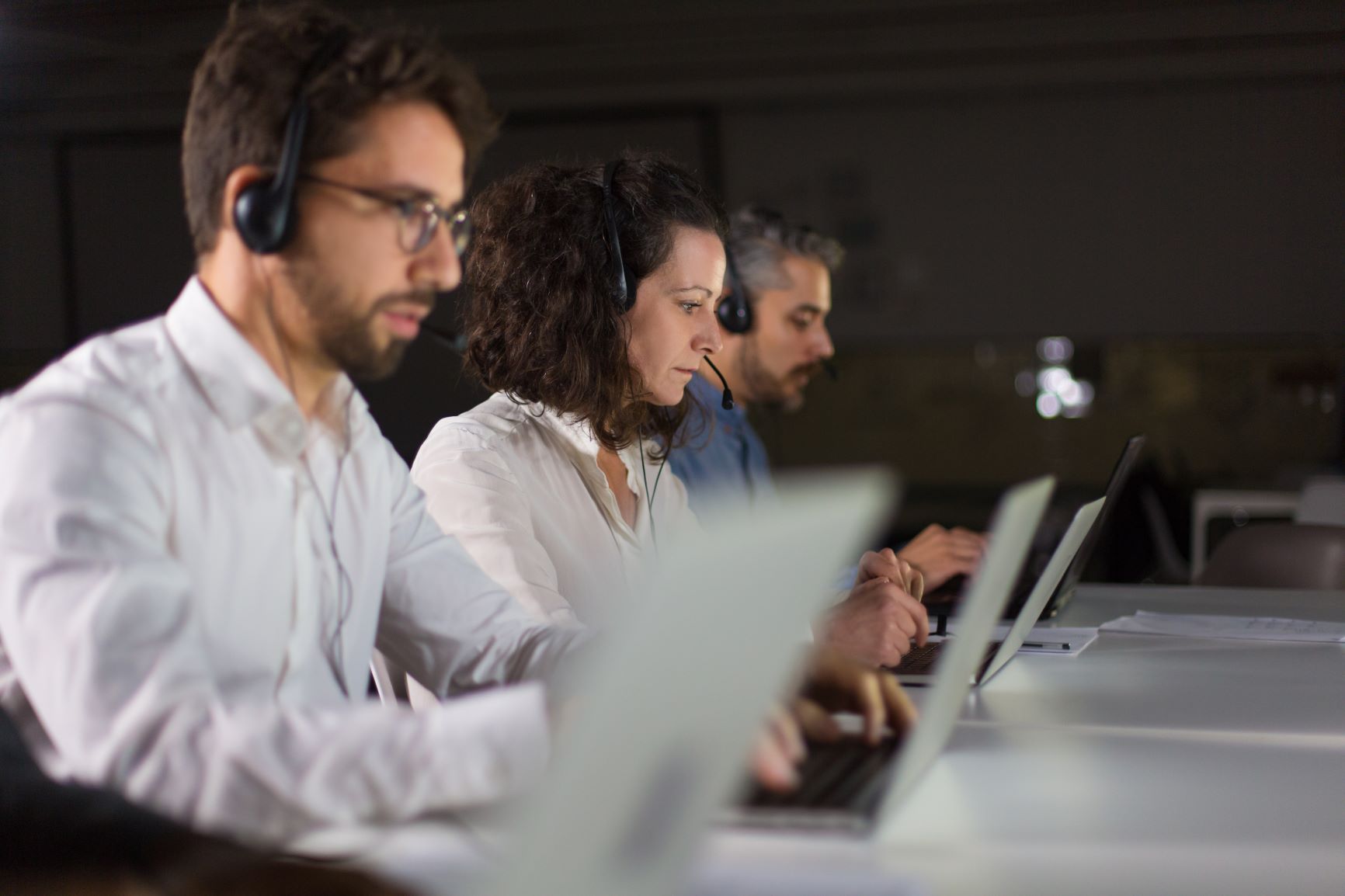 Atendentes com headset utilizando computadores