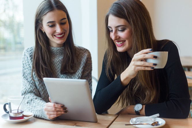 Pessoas utilizando tablet, sorrindo e conversando