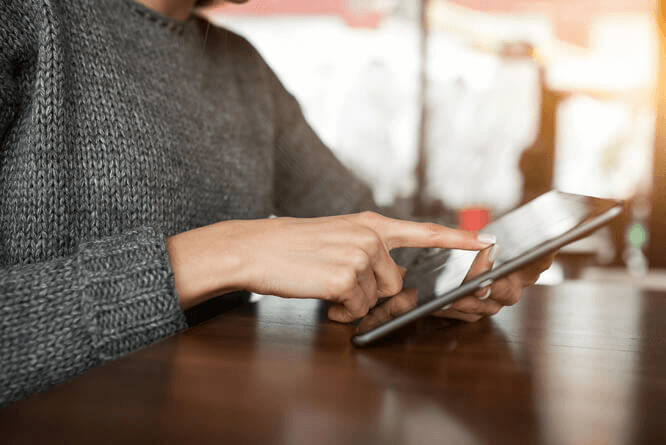 Mulher em cafeteria utilizando tablet