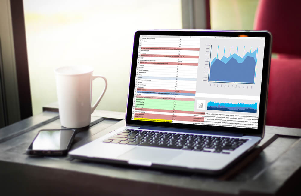 Computador com tela exibindo dados e gráficos